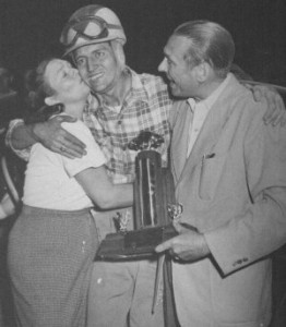 Tim Flock is congratulated by his sister, Ethel. Sam Nunis presents him with the trophy for winning Lakewood's Strictly Stock event.