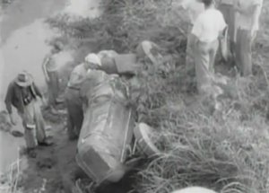 DeVore's car came to rest in the ditch after contact with Robson sent him out of control.  This screenshot came from the newsreel of the event, and came after fans helped DeVore from his car.