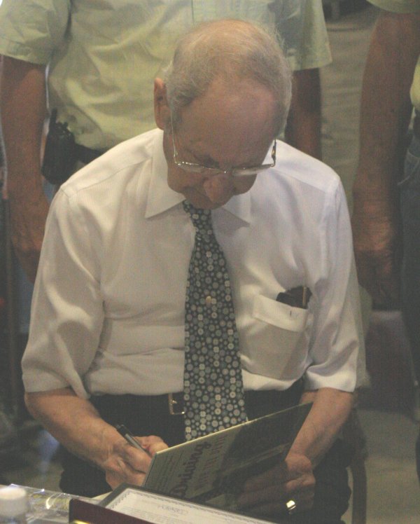 Mr. Parks signs a copy of "Driving With The Devil" for an admirer.