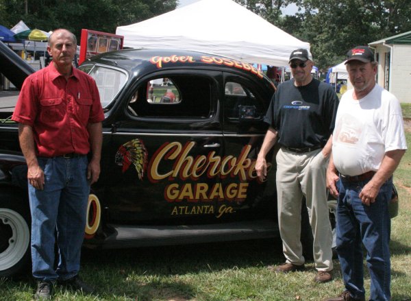 David Sosebee, C.L. Pritchett and Harold Pritchett, pictured left to right, pose with Gober Sosebee's racer.  The car is believed likely to be the one Sosebee won the Swayne Pritchett Memorial in back in 1948.