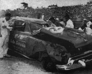 Smith looks over his wrecked car at Darlington in 1950.  Note the bandaged arm.  It took 25 years before all the broken glass was totally removed.