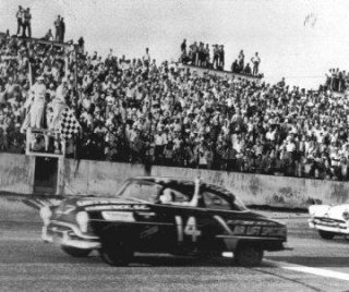 Fonty Flock waves to the crowd as he takes the checkered flag in the 1952 Southern 500.